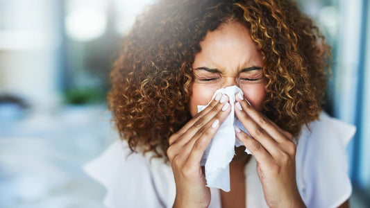 A woman sneezing into a tissue
